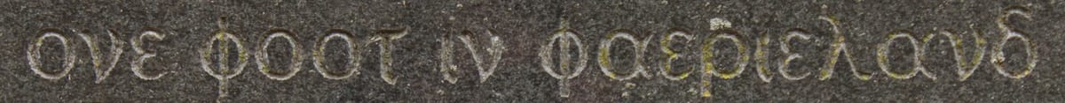 A string of Greek letters spelling out the English words "one foot in faerieland," etched on a marble monument